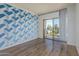 Bright bedroom features hardwood floors, custom wall art, and sliding glass door to the balcony at 4750 N Central Ave # G3, Phoenix, AZ 85012