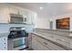 Modern kitchen with stainless steel appliances, granite countertops, and a breakfast bar area at 4950 N Miller Rd # 233, Scottsdale, AZ 85251