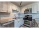 Close-up of a modern kitchen featuring stainless steel appliances, updated backsplash, and granite countertops at 4950 N Miller Rd # 233, Scottsdale, AZ 85251