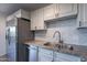 A close-up view of the kitchen featuring granite counters, stainless steel appliances, and white cabinets at 4950 N Miller Rd # 233, Scottsdale, AZ 85251