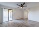 A bright living room with a sliding glass door to the balcony, wood flooring, and a ceiling fan at 4950 N Miller Rd # 233, Scottsdale, AZ 85251