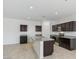 Well-lit kitchen with an island, and dark cabinets, and stainless steel appliances at 5058 E Umber Rd, San Tan Valley, AZ 85143