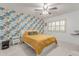Bright bedroom featuring a queen bed, accent wall, ceiling fan, and shuttered windows at 5104 N 32Nd St # 144, Phoenix, AZ 85018