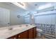 This bathroom has a double sink vanity, a shower/tub, and a patterned shower curtain at 5305 E Silverbell Rd, San Tan Valley, AZ 85143