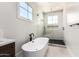 Bright bathroom showcasing a sleek standalone tub and glass-enclosed shower with herringbone tile at 5440 E Calle Camelia --, Phoenix, AZ 85018