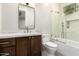 Well-lit bathroom featuring a wooden vanity, a decorative mirror, and a shower-over-bath with geometric tiles at 5440 E Calle Camelia --, Phoenix, AZ 85018