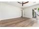 Bright bedroom features hardwood floors, a ceiling fan, and a large sliding glass door at 5440 E Calle Camelia --, Phoenix, AZ 85018