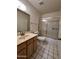Functional bathroom with tiled floor, vanity sink, and shower with sliding glass door for easy maintenance at 6845 W Caron Dr, Peoria, AZ 85345