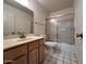 Bathroom with shower, light wood vanity with marble countertop and mirror at 6845 W Caron Dr, Peoria, AZ 85345