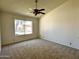 Bedroom with a ceiling fan and neutral carpet with a backyard view at 6845 W Caron Dr, Peoria, AZ 85345