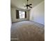 Spacious carpeted bedroom with ceiling fan and window offering ample light and a comfortable atmosphere at 6845 W Caron Dr, Peoria, AZ 85345
