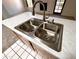 Close-up on a kitchen sink featuring stainless steel appliances and white countertops at 6845 W Caron Dr, Peoria, AZ 85345