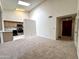 Bright and airy living room with carpeted floors, a high ceiling, and a view of the kitchen at 6845 W Caron Dr, Peoria, AZ 85345