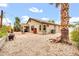 Large backyard showcasing a covered patio, a low-maintenance gravel landscape, and an attractive palm tree at 7425 N 75Th Dr, Glendale, AZ 85303