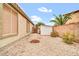 Low maintenance backyard with gravel and a shed, surrounded by block wall fencing and small palm trees at 7425 N 75Th Dr, Glendale, AZ 85303