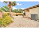 Well-kept backyard with gravel, a neatly kept AC unit, a block fence, and lush greenery at 7425 N 75Th Dr, Glendale, AZ 85303