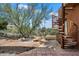 Charming back patio with a decorative fountain, mature desert landscaping, and an architectural spiral staircase at 7728 E Mary Sharon Dr, Scottsdale, AZ 85266