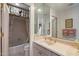 Cozy bathroom showcases neutral tiles, a shower-tub combo, and a sink with matching gold fixtures at 7728 E Mary Sharon Dr, Scottsdale, AZ 85266
