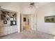 Bright bedroom featuring built-in shelving, soft carpeting, and a classic ceiling fan for added comfort at 7728 E Mary Sharon Dr, Scottsdale, AZ 85266