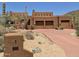 Stunning desert home featuring a three-car garage, earthy stucco exterior, and native landscaping at 7728 E Mary Sharon Dr, Scottsdale, AZ 85266