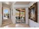 Bright foyer featuring tiled floors, a hallway leading to a patio, and a large ornate painting at 7728 E Mary Sharon Dr, Scottsdale, AZ 85266