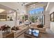 Bright living room featuring white couches, a large window, desert views, and a spiral staircase outside at 7728 E Mary Sharon Dr, Scottsdale, AZ 85266