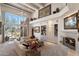 Bright living room featuring a fireplace, white couches, built-in shelving, and a large window with mountain views at 7728 E Mary Sharon Dr, Scottsdale, AZ 85266