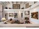 Bright living room featuring a fireplace, white couches, built-in shelving, and decor on the upper walls at 7728 E Mary Sharon Dr, Scottsdale, AZ 85266