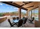 Covered patio features comfortable seating and a glass-top table overlooking a pool and desert landscape at 7728 E Mary Sharon Dr, Scottsdale, AZ 85266