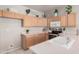 Functional kitchen featuring light wood cabinetry, a stainless steel stove, and a white countertop with a sink at 8802 E University Dr # 28, Mesa, AZ 85207