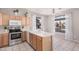 Bright kitchen area with light-toned cabinets, a stainless steel microwave, and a large window for natural light at 8802 E University Dr # 28, Mesa, AZ 85207