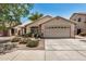 Inviting home exterior featuring a two-car garage and desert landscaping at 9135 W Hazelwood St, Phoenix, AZ 85037