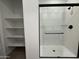 Modern bathroom features a walk-in shower with black hardware and glass door, plus open shelving at 9544 W Parkway Dr, Tolleson, AZ 85353