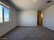 Carpeted bedroom has a window, neutral paint, and a doorway to the rest of the house at 9544 W Parkway Dr, Tolleson, AZ 85353