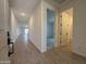 Bright hallway with wood-look flooring leading to a bathroom and bedrooms at 9544 W Parkway Dr, Tolleson, AZ 85353