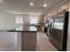 Modern kitchen features stainless appliances, gray cabinets, island, and stylish backsplash at 9544 W Parkway Dr, Tolleson, AZ 85353