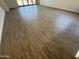 Open concept living space with wood-style tile flooring and sliding glass door at 9544 W Parkway Dr, Tolleson, AZ 85353
