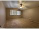 Spacious bedroom features plush carpet, a ceiling fan, and bright, natural light at 970 W Leah Ln, Gilbert, AZ 85233
