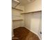 Walk-in closet featuring wood floors and open shelving for organization at 970 W Leah Ln, Gilbert, AZ 85233
