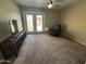 Bright living area with ceiling fan, entertainment center, and glass doors to outside patio at 970 W Leah Ln, Gilbert, AZ 85233