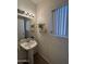 Cozy powder room with pedestal sink, stylish decor, and window with modern blinds at 970 W Leah Ln, Gilbert, AZ 85233