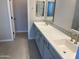 Bathroom featuring double sinks, vanity with modern hardware, and tiled flooring at 9963 W Verde Ln, Avondale, AZ 85392