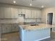 Open-concept kitchen boasts gray cabinets, granite countertops, and an island perfect for food prep and entertaining at 9963 W Verde Ln, Avondale, AZ 85392