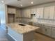 Spacious kitchen with gray cabinets, granite countertops, and a large center island with a sink at 9963 W Verde Ln, Avondale, AZ 85392
