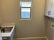 Bright laundry room featuring a stainless steel sink and a window for natural light at 9963 W Verde Ln, Avondale, AZ 85392