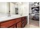 Bathroom featuring a double sink vanity with cherry wood cabinets and decorative mirror at 10221 E Wavelength Ave, Mesa, AZ 85212