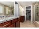 Bathroom featuring double sinks, granite countertop, and tiled shower with glass door at 10221 E Wavelength Ave, Mesa, AZ 85212