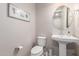 Neutral half-bathroom featuring a pedestal sink, oval mirror, and artwork at 10221 E Wavelength Ave, Mesa, AZ 85212