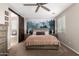 Bedroom featuring a king bed, ceiling fan, barn door, and decorative forest tapestry at 10221 E Wavelength Ave, Mesa, AZ 85212