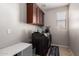 Laundry room featuring a washer and dryer with storage cabinets above at 10221 E Wavelength Ave, Mesa, AZ 85212